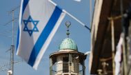 An Israeli flag waves in front of the minaret of a mosque in the Arab quarter of Jerusalem's Old City on November 14, 2016. AFP / THOMAS COEX