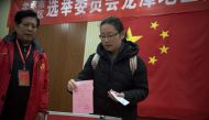 In this picture taken on November 15, 2016, a woman casts her vote at a polling station in Beijing. AFP / NICOLAS ASFOURI 