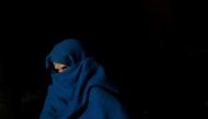 A woman wrapped in a blanket sits on a footpath as she waits for the bank to open to exchange her old high-denomination banknotes in the early hours, in the old quarters of Delhi, India, November 16, 2016. REUTERS/Adnan Abidi 
