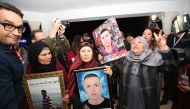 Tunisian mothers of a torture victims carry their sons' portraits as they arrive for a hearing before the The Truth and Dignity Commission (IVD) in Tunis on November 17, 2016. Victims of murder, rape and torture under successive dictatorships started test