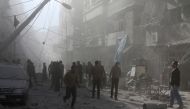 People walk on the debris buildings after the war crafts belonging to the Assad Regime carried out airstrikes on residential areas at Firdevs neighborhood in Aleppo, Syria on November 18, 2016. ( Jawad al Rifai - Anadolu Agency )
