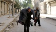 A Syrian civil defence volunteer, known as the White Helmets, carries an injured man on November 19, 2016 following a reported air strike on Aleppo's rebel-held neighbourhood of Bab al-Nayrab. Intense government air strikes and artillery fire killed at le