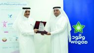 Eng Fahad Abdullah Al Subaiey, Chief Marketing Officer at Woqod, being presented with a commemorative plaque by a Qatar Cancer Society official.