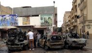 People look at the remnants of a car at the scene of a car bomb in Benghazi, Libya, November 21, 2016. REUTERS/Stringer