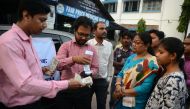 Indian banking staff of the State Bank of India assist customers to withdraw money with the use of a mobile banking machine at Siliguri District hospital in Siliguri on November 22, 2016. Prime Minister Narendra Modi sent shockwaves through the country by