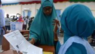 (FILES) This file photo taken on November 16, 2016 shows a Somali polling agent (R) explaining the voting procedure to a voter before she casts her ballot in Baidoa. AFP / SIMON MAINA