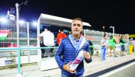 Argentinean football legend Gabriel Omar Batistuta, nicknamed Batigol, poses for a photo with a glove, signed by FIA World Touring Car Champion Jose Maria Lopez, during the WTCC DHL Race of Qatar at the Losail International Circuit on Friday. Batistuta pl