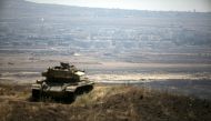 FILE PHOTO: The Syrian area of Quneitra is seen in the background as an out-of-commission Israeli tank parks on a hill, near the ceasefire line between Israel and Syria, in the Israeli-occupied Golan Heights, August 21, 2015. REUTERS/Baz Ratner/File Photo