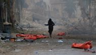 Image depicts death] A teenage girl runs among the dead bodies on the ground at the site of blast after Assad Regime's strike over civilians in residential areas of Jib Al-Quebeh neighborhood of Aleppo, Syria on November 30, 2016. Ibrahim Ebu Leys - Anado