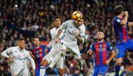 Real Madrid's defender Sergio Ramos (C) heads a ball to score the equalizer past Real Madrid's French defender Raphael Varane (3rdL) and Barcelona's Argentinian defender Javier Mascherano (R) during the Spanish league football match FC Barcelona vs Real M