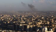 A general view taken from the government-held side of Aleppo shows smoke billowing during fighting between Syrian regime forces and rebel fighters in east Aleppo, on December 3, 2016. AFP / Youssef KARWASHAN
