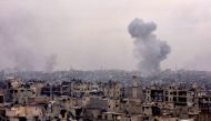 Smoke rises from buildings in Aleppo's eastern Karm al-Jabal neighbourhood on December 5, 2016 (AFP Photo/George Ourfalian)