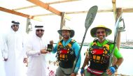 Katara General Manager Dr Khalid bin Ibrahim Al Sulaiti presents a memento to Kuwaiti kayakers Bashar Al Huneidi and Mansoor Al Safran.