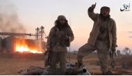 A still image taken from a video released by Islamic State-affiliated Amaq news agency, said to be in Palmyra, on December 11, 2016, purports to show Islamic State fighters in front of silos on fire and said to have been taken over by them. 