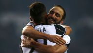 Juventus' Argentinan forward Gonzalo Higuain (R) jubilates with Juventus' Argentinan forward Paulo Dybala at the end of the Italian Serie A football match between Torino and Juventus on December 11, 2016 at the 'Grande Torino Stadium' in Turin. / AFP / MA