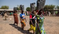 Displaced women carrying sacks of food aid received during a distribution at the Cathedral of Yola state capital of Adamawa, Nigeria (AFP)