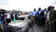 Kenya's Deputy President William Ruto looks at the wreckage of a police truck involved in an accident after a fireball from a tanker engulfed several vehicles and killed at least 25 people, near the Rift Valley town of Naivasha, west of Kenya's capital Na