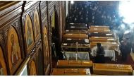 Egyptian clergymen stand next to the coffins of the victims of a bomb explosion that targeted a Coptic Orthodox Church the previous day in Cairo, during their funeral in the Egyptian capital's Nasr City neighbourhood on December 12, 2016. / AFP / Khaled D