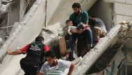 PHOTO: Syrian men remove a baby from rubble in a neighbourhood of Aleppo. (AFP/Ameer Alhalbi)