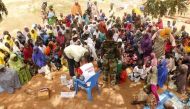 People who were rescued after being held captive by Boko Haram, sit as they wait for medical treatment at a camp near Mubi, northeast Nigeria October 29, 2015. REUTERS/Stringer