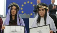 Nadia Murad Basee Taha (L) and Lamiya Aji Bashar, both Iraqi women of the Yazidi faith, pose with the 2016 Sakharov Prize during an award ceremony at the European Parliament in Strasbourg, France, December 13, 2016. REUTERS/Vincent Kessler
