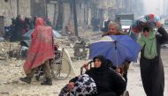 Syrian residents, fleeing violence in the restive Bustan al-Qasr neighbourhood, arrive in Aleppo's Fardos neighbourhood on December 13, 2016, after regime troops retook the area from rebel fighters. Syrian rebels withdrew from six more neighbourhoods in t