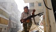 A Free Syrian Army fighter takes cover during clashes with Syrian Army in the Salaheddine neighbourhood of central Aleppo August 7, 2012. REUTERS/Goran Tomasevic/File Photo
