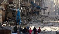 Syrians walk over rubble of damaged buildings, while carrying their belongings, as they flee clashes between government forces and rebels in Tariq al-Bab and al-Sakhour neighborhoods of eastern Aleppo towards other rebel held besieged areas of Aleppo, Syr
