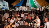 Surrounded by a mostly young crowd, seven musicians sit around a table with the small four-string guitar called a cavaquinho, the cuica drum and a tambourine. AFP