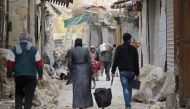 Syrians walk in the old market in the government-held old city of the northern embattled city of Aleppo on December 17, 2016. Trapped Syrian civilians and rebels waited desperately Saturday for evacuations to resume from an opposition-held enclave in Alep