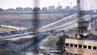 Vehicles from the International Red Cross and from the Syrian Red Crescent wait at the government-controlled crossing of Ramoussa, on the southern outskirts of Aleppo on December 18, 2016, during an evacuation operation of rebel fighters and civilians fro