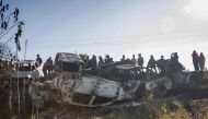 Bysanders gather to look at the burnt out shells of vehicles that had been set alight by protesters in Imphal, the capital of India's northeastern state of Manipur, on December 19, 2016. The violence began when protesters angry with an ongoing economic bl