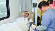 A Qatar Islamic Bank employee donating blood.