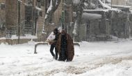  Syrians walk in a snow covered street in the town of Maaret al-Numan, in Syria's northern province of Idlib, on December 21, 2016. Rebels and civilians who have sought refuge in the opposition-held province of Idlib, most recently from second city Aleppo
