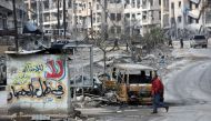 A Syrian man walks past the wreckage of cars in the former rebel-held Ansari district in the northern Syrian city of Aleppo on December 23, 2016 after Syrian government forces retook control of the whole embattled city. Syrian troops cemented their hold o