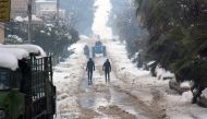 Syrians walk in a snow covered street in the town of Maaret al-Numan, in Syria's northern province of Idlib, on December 22, 2016. AFP / GHAITH OMRAN
