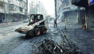 A tractor removes rubble as the Syrian government starts to clean up areas formerly held by opposition forces in the northern city of Aleppo, yesterday.