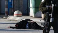 A Palestinian woman lies on the ground after she was shot and wounded by Israeli security forces while approaching the Qalandia checkpoint with a knife, between Jerusalem and the occupied West Bank on December 30, 2016, according to Israeli police. AFP / 