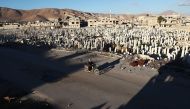 A Syrian man rides a motorbike past a cemetery in the rebel-held town of Douma, on the eastern outskirts of Damascus, on January 3, 2017. / AFP / Abd Doumany
