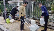 Syrians fill plastic containers with water at a public fountain in the capital Damascus on January 3, 2017. AFP / LOUAI BESHARA
