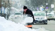A man removes snow from a car in a suburb of Sofia in Bulgaria after heavy snowfall yesterday. Snowstorms and temperatures plunging to minus 19 degrees Celsius have brought road traffic to a standstill across the country, officials said.