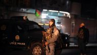 This picture taken on January 10, 2017 shows Afghan policemen standing guard at the site of an explosion near the governor's compound in Kandahar. AFP / JAWED TANVEER