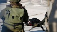 FILE PHOTO: A Palestinian woman lies on the ground after she was shot and wounded by Israeli security forces  at Qalandia checkpoint between Jerusalem and the occupied West Bank on December 30, 2016 (AFP /ABBAS MOMANI) 