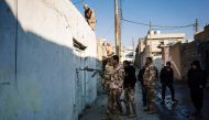 A demining expert from the Iraqi army points his weapon towards a locked door as he searches for booby-trapped buildings in eastern Mosul on January 16, 2017, during an ongoing military operation against Islamic State (IS) group jihadists.  AFP / Dimitar 