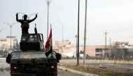 A member of the Iraqi counter-terrorism service (CTS) flashes the V-gesture as he stands atop a humvee patrolling the Andalus neighbourhood in the city of Mosul after its liberation from the Islamic state group (IS) control, during the ongoing military op
