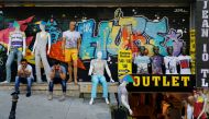 Men sit outside a discount clothing retail store in Istanbul, July 13, 2016 (REUTERS / Murad Sezer) 