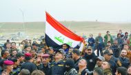Iraqi people raise the national flag in the same place where Islamic State militants raised their flag two years ago in east Mosul, Iraq, yesterday.