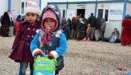 Displaced Iraqi children, who fled the violence around the northern Iraqi city of Mosul, receive aid at the al-Khazer refugee camp some 40 kilometres east of Arbil, on January 31, 2017. / AFP / Mahmud SALEH
