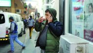 A man sips tea at a cafe in Industrial Area yesterday. People took to the outdoors covered in warm clothes as sunshine brought some relief from chilly conditions on Friday. Pic: Salim Matramkot/The Peninsula