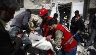 Members of the Syrian Arab Red Crescent and residents search through the rubble for bodies following an airstrike in the rebel-held city of Douma in Eastern Ghouta, on February 26, 2016 (AFP Photo/Abd Doumany).